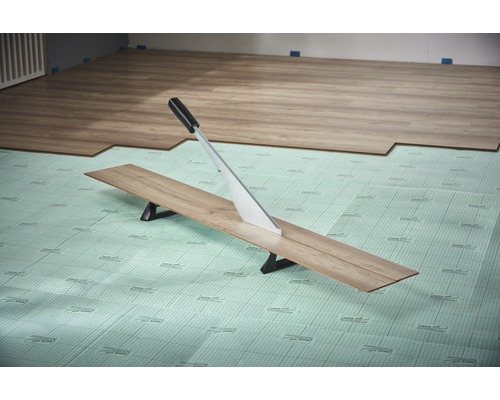 Laminatschneider schneidet Laminatdiele auf Dämmunterlage