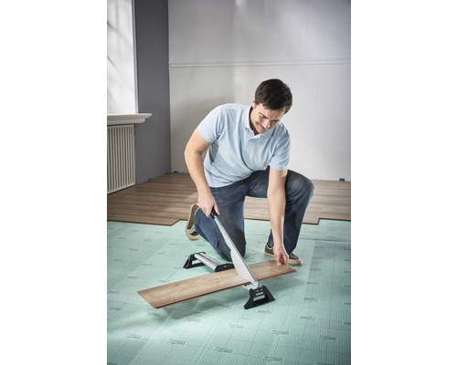 Mann schneidet Laminat mit einem Laminatschneider