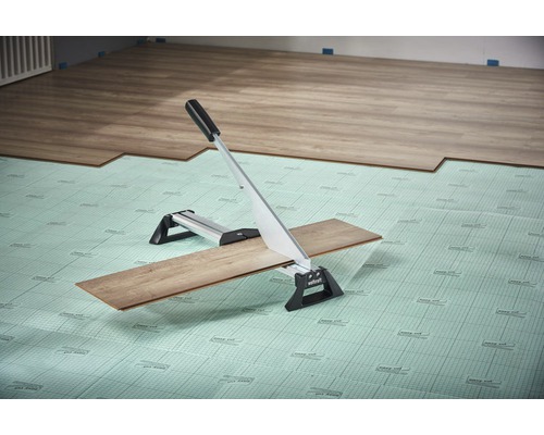 Laminatschneider schneidet Laminat auf Dämmunterlage