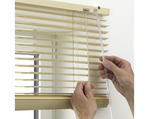 Person justiert Jalousien mit Bedienkordel und Wendestab.