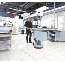 Frau reinigt Boden mit Reinigungsmaschine im Einzelhandel.