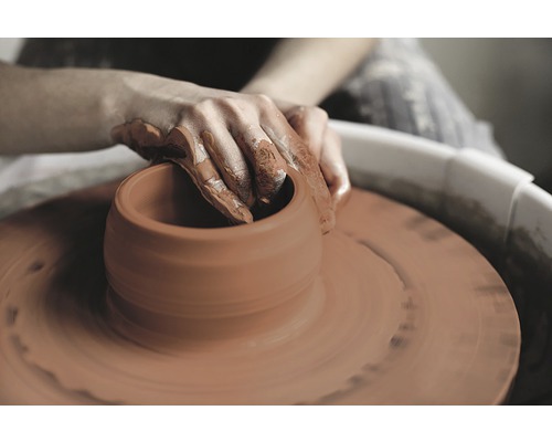 Person formt Keramik auf einer Töpferscheibe