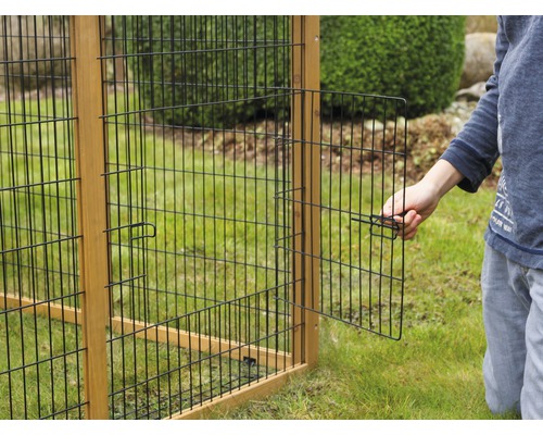 Detailansicht eines Kleintiergeheges mit Gittertür und Holzrahmen