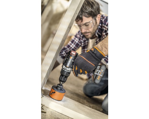 Mann bohrt mit einem Akku-Bohrschrauber ein Loch in einen Holzrahmen