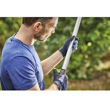 Eine Person mit Handschuhen hält ein Gartenwerkzeug.
