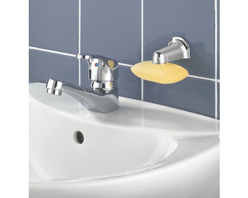 Auf einem Waschbecken befinden sich eine Armatur und eine Seifenablage mit Seife.