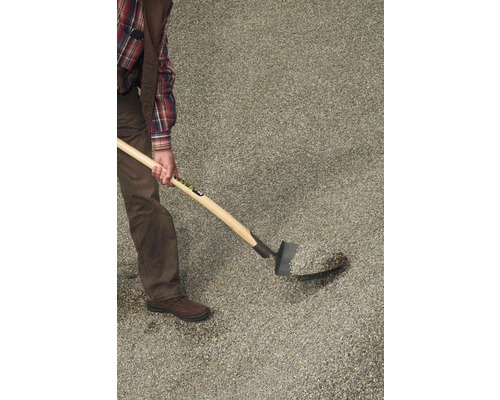 Person schaufelt Ziersplitt mit einer Schaufel