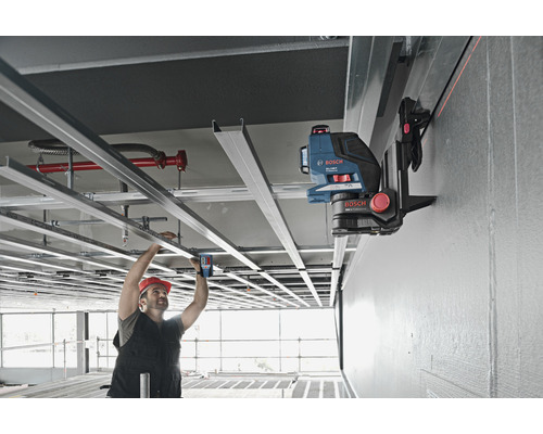 Handwerker verwendet einen Linienlaser für Deckenarbeiten im Innenbereich.