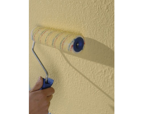 Eine Person streicht eine Wand mit einer Farbwalze.