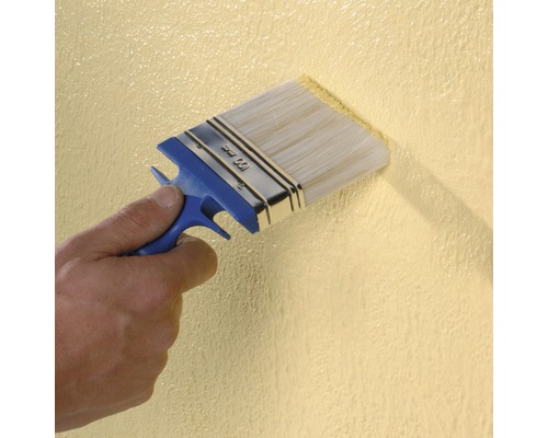 Eine Person streicht mit einem 100 Millimeter breiten Pinsel eine Wand.