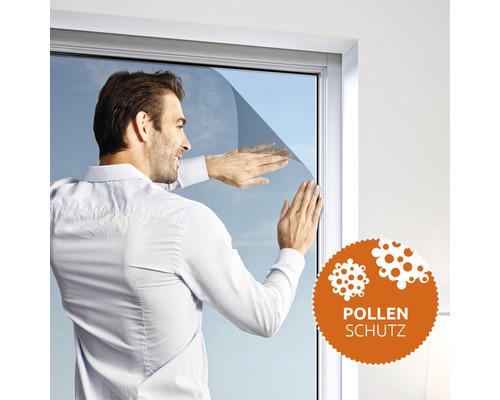 Mann bringt Pollenschutzfolie an einem Fenster an. Pollenschutz Siegel.