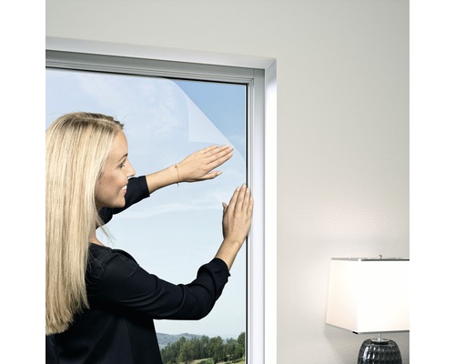 Fliegengitter Windhager Elastic PLUS für Fenster ohne Bohren weiss 130x150 cm Frau befestigt Fensterfolie an einem Fenster