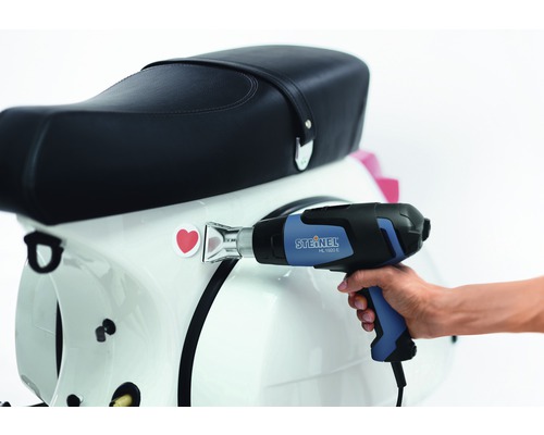 Heißluftpistole beim Anbringen eines Aufklebers auf einem Roller.