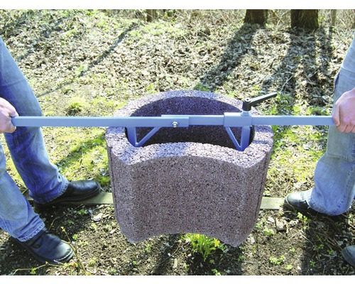 Zwei Personen transportieren einen Pflanzring mit einem Tragebügel.