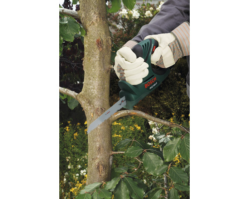 Person schneidet Baumast mit einer Astsäge