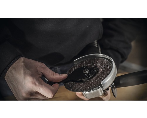 Person montiert eine Trennscheibe an einem Winkelschleifer.