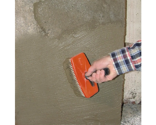 Handwerker bearbeitet Wand mit einer Quastbürste