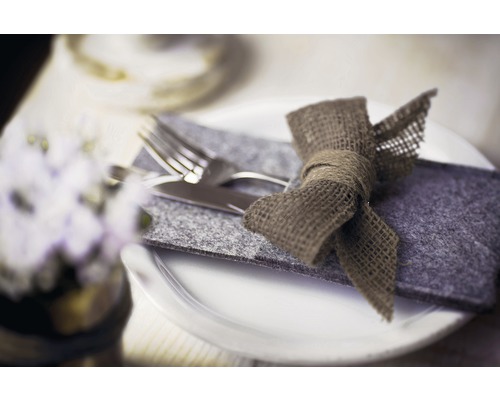 Gedeckter Tisch mit Besteck in Filzhülle und Schleife