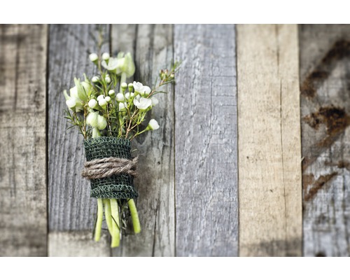 Blumenstrauß aus weißen Blüten und grünen Zweigen, umwickelt mit Juteband