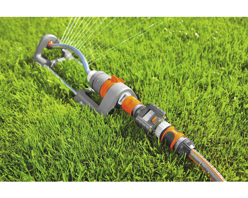 Rasensprenger mit Bewässerungscomputer und Gartenschlauch auf Rasen