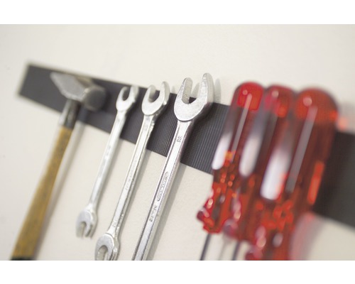 Hammer, Schraubenschlüssel und Schraubendreher an magnetischer Werkzeugleiste