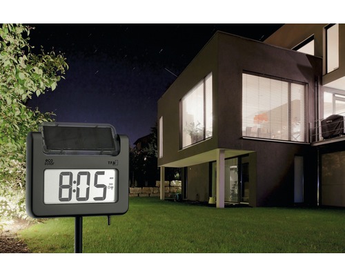 Gartenuhr mit Solarpanel im Einsatz vor einem modernen Haus