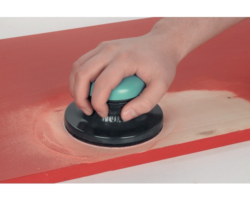 Person schleift Holzbrett mit Handschleifer