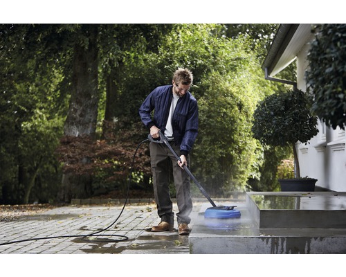 Mann reinigt mit einem Hochdruckreiniger eine Außentreppe.