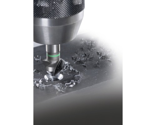 Holzsenker bohrt in Werkstück mit Metallspänen