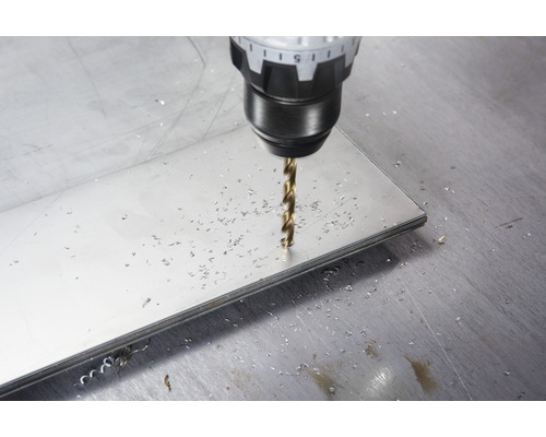 Ein Bohrer bohrt ein Loch in eine Metallplatte.