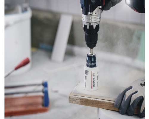 Bohrmaschine mit Lochsäge bohrt in ein Werkstück.