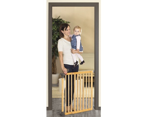 Mutter mit Kind vor einem Holztürschutzgitter