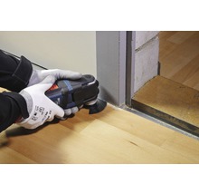 Eine Person benutzt ein Multifunktionswerkzeug zum Schneiden von Holzböden.