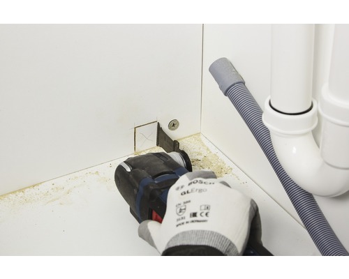Oszillierendes Elektrowerkzeug im Einsatz zum Schneiden eines Ausschnitts in eine Schrankwand für Sanitärinstallationen
