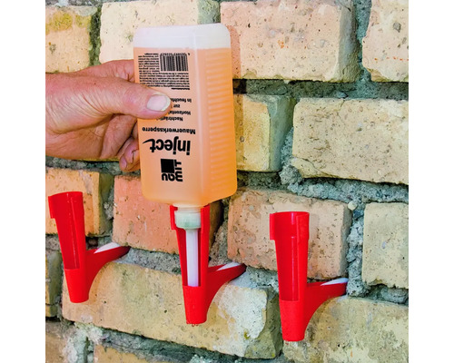 Injektionsmittel zur nachträglichen Mauerwerkssperre wird in eine Wand aus Ziegelsteinen injiziert.