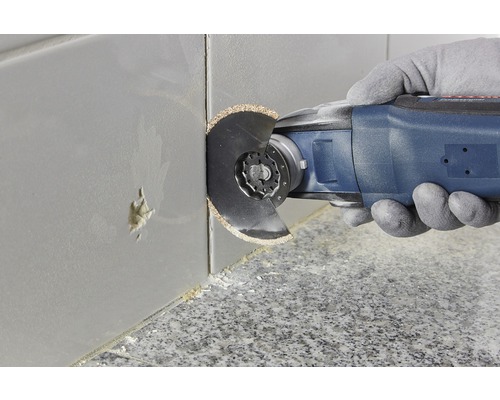 Eine oszillierende Multifunktionswerkzeug schneidet eine Fliese.