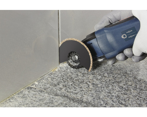 Multifunktionswerkzeug im Einsatz zum Entfernen von Fugen zwischen Fliesen.