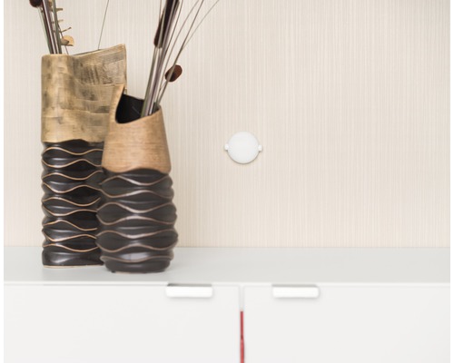 Zwei dekorative Vasen und eine runde Wandlampe an der Wand