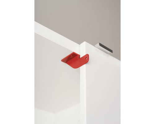 Roter Möbelverbinder an einem weißen Schrank befestigt.