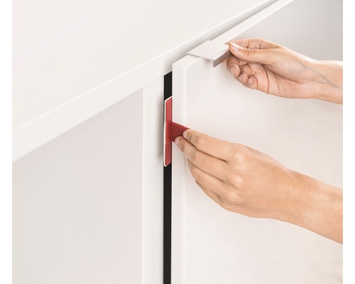 Eine Person befestigt einen Schrankschloss an einer Schranktür.