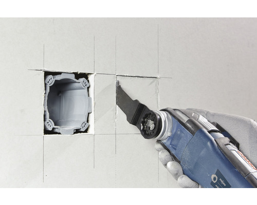 Oszillierendes Elektrowerkzeug schneidet eine Öffnung in eine Wand für eine Gerätedose