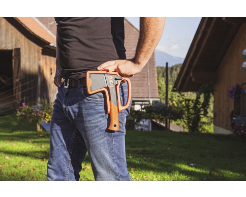 Person mit Axt im Halfter am Gürtel in Außenaufnahme.