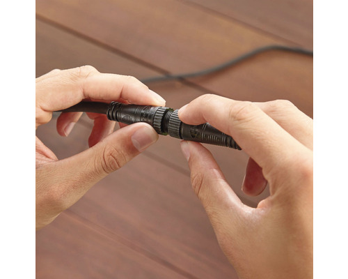 Zwei Hände verbinden ein Kabel