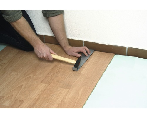 Verlegen von Laminat mit Hammer und Zugeisen