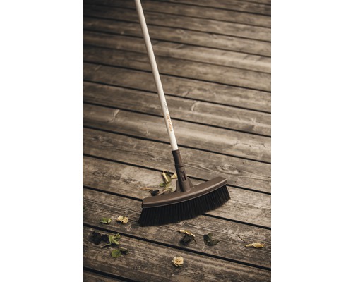 Fiskars Kehrbesen auf Holzterrasse mit Laub
