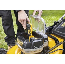 Eine Person setzt einen DeWalt 18 Volt 5.0 Ah Akku in einen Rasenmäher ein.