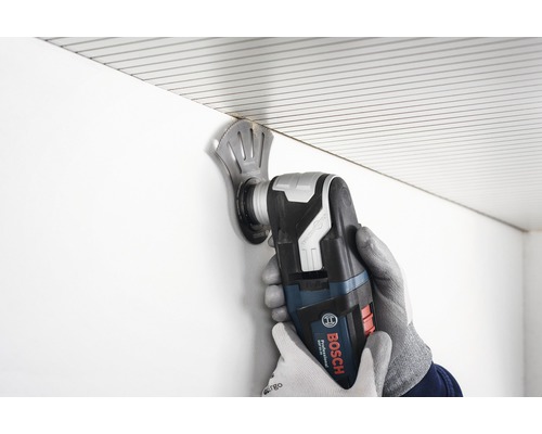 Eine Person benutzt einen Multifunktionsschneider von Bosch zum Schneiden von Material.