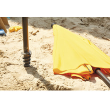Gelber Sonnenschirm mit Erdanker im Sand