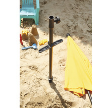 Sandszene mit Sonnenschirmständer, Spielzeug und Liegestuhl im Sand