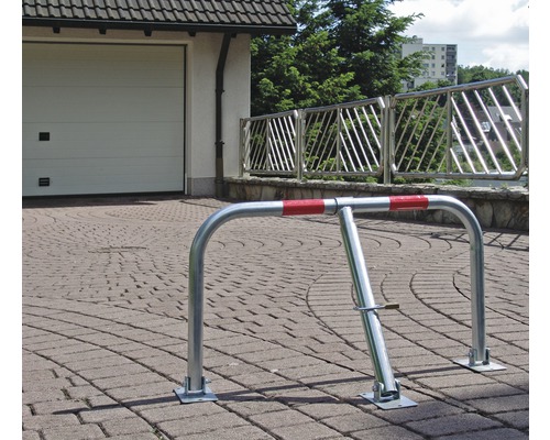 Parkplatzsperre aus Metall mit Schloss vor einer Garage